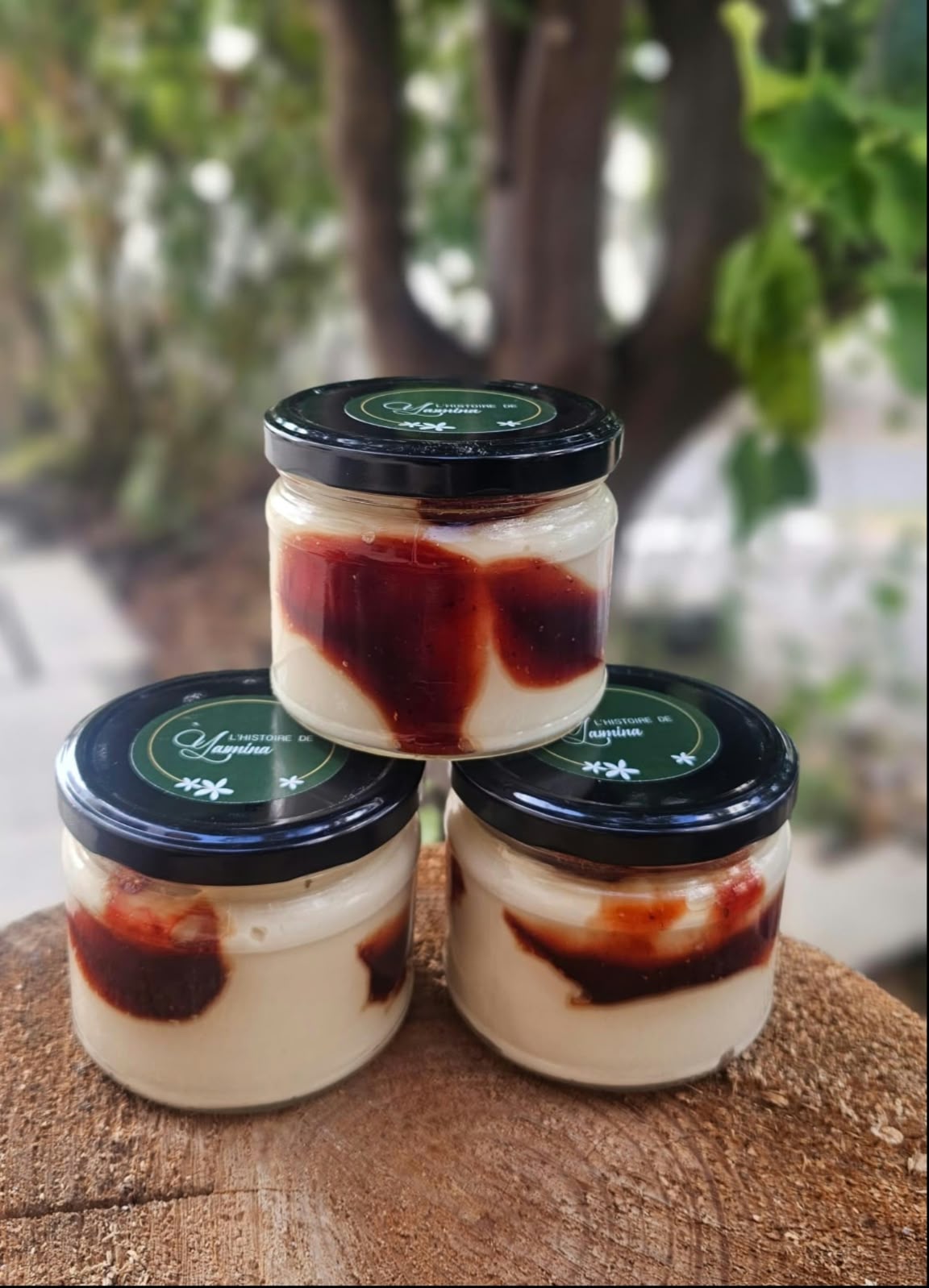Three stacked jars of creamy spread swirled with red fruit, topped with L'histoire de Yasmina lids